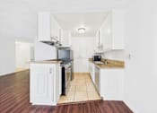Thumbnail 18 of 88 - A kitchen with white cabinets and a black stove top oven.
