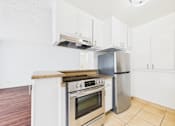 Thumbnail 17 of 88 - A kitchen with a stove top oven and a refrigerator.