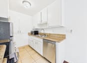 Thumbnail 19 of 88 - A kitchen with white cabinets and a granite countertop.