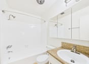 Thumbnail 24 of 88 - A white bathroom with a sink, toilet and bathtub.