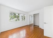 Thumbnail 28 of 88 - A room with a white door and a window with a view of trees.