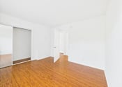 Thumbnail 30 of 88 - A room with a wooden floor and white walls.