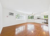 Thumbnail 27 of 88 - A large empty room with wooden floors and white walls.