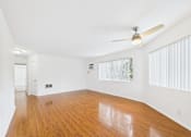 Thumbnail 29 of 88 - A room with wooden floors and a ceiling fan.