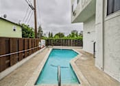 Thumbnail 88 of 88 - A small pool in a backyard with a concrete floor.