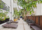 Thumbnail 87 of 88 - A patio with a table and chairs surrounded by plants.