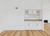 Thumbnail 119 of 208 - A kitchen with white cabinets and a wooden floor.