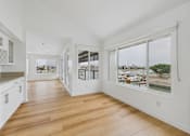 Thumbnail 126 of 208 - A long hallway with white walls and wood floors.