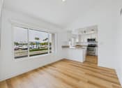 Thumbnail 118 of 208 - A kitchen with white cabinets and a wooden floor.