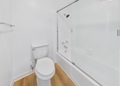 Thumbnail 131 of 208 - A white toilet sits next to a glass shower stall.