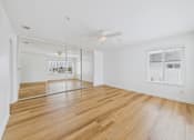 Thumbnail 125 of 208 - A room with wooden floors and a ceiling fan.