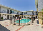 Thumbnail 60 of 65 - A pool surrounded by a fence in front of a building.