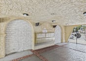 Thumbnail 59 of 65 - A white brick wall with a stone archway and a sign on the wall.