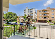 Thumbnail 19 of 19 - A balcony view of a residential area with buildings and cars.