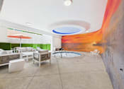 Thumbnail 73 of 77 - A modern outdoor seating area with a pool and a mural on the wall.