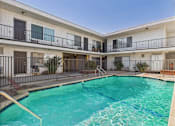 Thumbnail 65 of 65 - A swimming pool in front of a building with balconies.