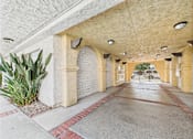 Thumbnail 62 of 65 - A long corridor with arched columns and a brick border.