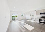 Thumbnail 14 of 22 - A spacious, well-lit room with a wooden floor and white walls.