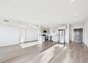 Thumbnail 13 of 22 - A spacious kitchen with white appliances and a wooden floor.