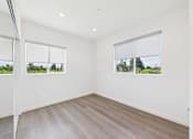 Thumbnail 17 of 22 - A room with a white wall and a window with a view of trees.