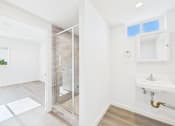 Thumbnail 20 of 22 - A bathroom with a sink, mirror, and shower.