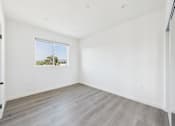 Thumbnail 19 of 22 - A room with a window and a wooden floor.