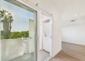 Thumbnail 16 of 22 - A white refrigerator is in a room with a glass door.