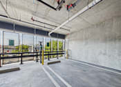 Thumbnail 103 of 163 - A parking garage with concrete walls and a concrete floor.