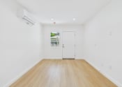 Thumbnail 19 of 28 - A room with a white door and a window showing greenery outside.