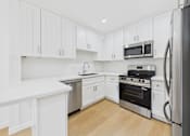 Thumbnail 17 of 28 - A kitchen with white cabinets and stainless steel appliances.