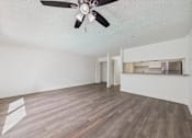 Thumbnail 22 of 29 - A room with a ceiling fan and wooden flooring.