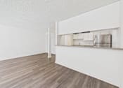 Thumbnail 21 of 29 - A kitchen with white cabinets and a wooden floor.