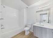 Thumbnail 48 of 52 - A white bathroom with a toilet, sink, and bathtub.