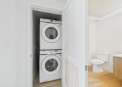 Thumbnail 47 of 52 - A white washing machine and dryer in a small laundry room.