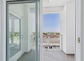 Thumbnail 42 of 52 - A view of a balcony through a glass door.