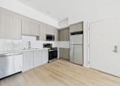 Thumbnail 40 of 52 - A kitchen with wooden floors and white walls.