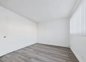 Thumbnail 11 of 36 - A room with a wooden floor and white walls.