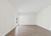 Thumbnail 40 of 45 - Empty room with wooden floor and white walls.