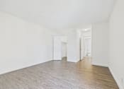 Thumbnail 45 of 45 - A room with white walls and wooden flooring.