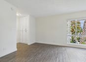 Thumbnail 36 of 45 - A room with a window showing a view of trees and a wooden fence.