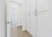 Thumbnail 43 of 45 - A white bathroom with a toilet and a white door.