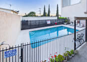 Thumbnail 10 of 13 - A pool surrounded by a black fence with a sign that says "Keep Closed".