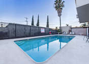 Thumbnail 9 of 13 - A pool with a fence and trees in the background.