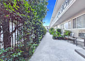 Thumbnail 11 of 13 - A concrete pathway leads to a building with a balcony.