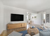 Thumbnail 10 of 16 - A living room with a television, chairs, and a table.