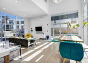 Thumbnail 22 of 22 - a living room with large windows and a table and chairs