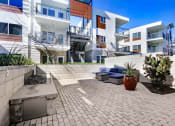 Thumbnail 18 of 22 - a patio with a couch in front of some apartments