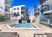 Thumbnail 20 of 22 - an apartment pool with two chairs in front of an apartment building