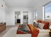 Thumbnail 5 of 22 - a bedroom with an orange blanket and pillows on a couch