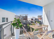 Thumbnail 4 of 22 - a balcony with a table and chairs and a view of a city